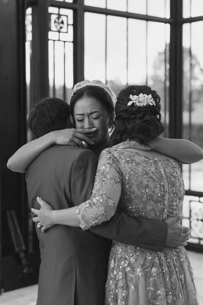 candid photo of bride hugging her mom and dad